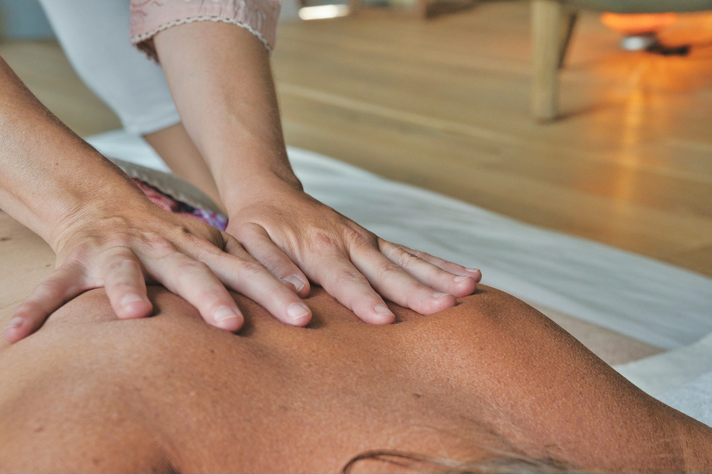 Massage suédois — mains massant le dos